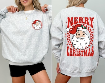 May include: Light grey sweatshirt featuring a Santa Claus graphic on the front and back. The front has a small Santa Claus design within a red and white checkered circle. The back has a larger Santa Claus design with the words "MERRY CHRISTMAS".