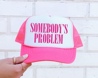 Gorra trucker snapback rosa brillante con el lema "Problema de alguien", atrevida y divertida.