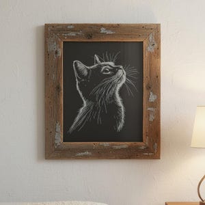 May include: A framed black and white cat portrait. The cat is depicted in profile, looking upwards with detailed whiskers. The artwork is set within a rustic, weathered wooden frame, adding a touch of vintage charm to the piece. The cat's fur is detailed.