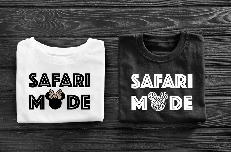 K&ouml;nnte beinhalten: Zwei wei&szlig;e T-Shirts mit schwarzem Text, der "Safari Mode" lautet, und einem schwarzen und wei&szlig;en Mickey-Maus-Kopf mit Schleife. Ein Shirt ist wei&szlig; und das andere ist schwarz.