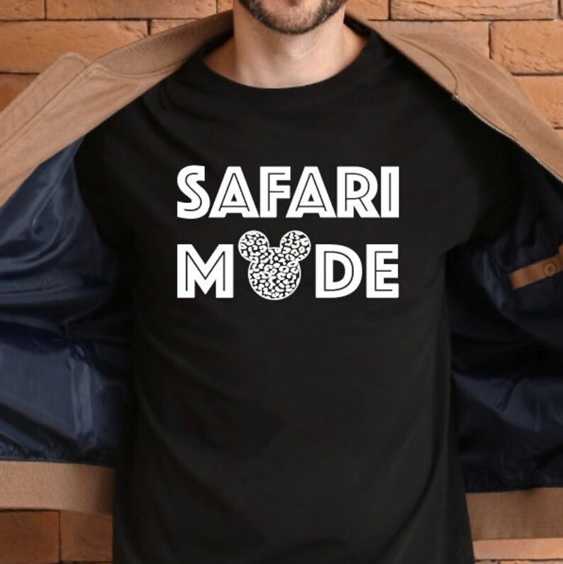 K&ouml;nnte beinhalten: Schwarzes T-Shirt mit wei&szlig;em Text "SAFARI MODE" und einem wei&szlig;en Mickey Mouse Kopf mit Leopardenmuster.