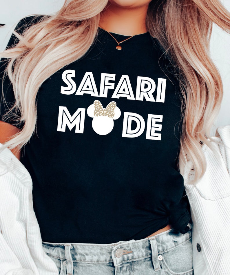 K&ouml;nnte beinhalten: Schwarzes T-Shirt mit wei&szlig;em Text "Safari Mode" und einer wei&szlig;en Silhouette von Mickey Mouse mit einer goldenen Glitzer Schleife.