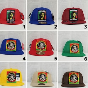Könnte beinhalten: Neun verschiedene farbige Baseballkappen mit einem Patch mit dem Bild von Bob Marley und den Worten "One Love" und "One People".