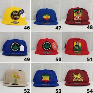 Puede incluir: Diez gorras de béisbol diferentes con varios diseños y colores. Las gorras presentan diferentes logotipos y textos, incluyendo "One Love", "Bob Marley" y "The Lion of Judah".