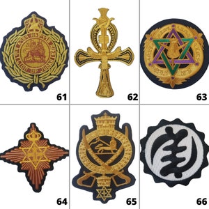 Puede incluir: Seis parches bordados con varios símbolos religiosos. Los parches son dorados, negros y blancos con una variedad de diseños que incluyen un león, una cruz, una estrella y una corona.
