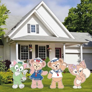 May include: Four cartoon character yard decorations are displayed on a green lawn in front of a white house. The characters include a green cat, a bear in a sailor outfit, a bear in a sailor outfit, and a fox with a flower.
