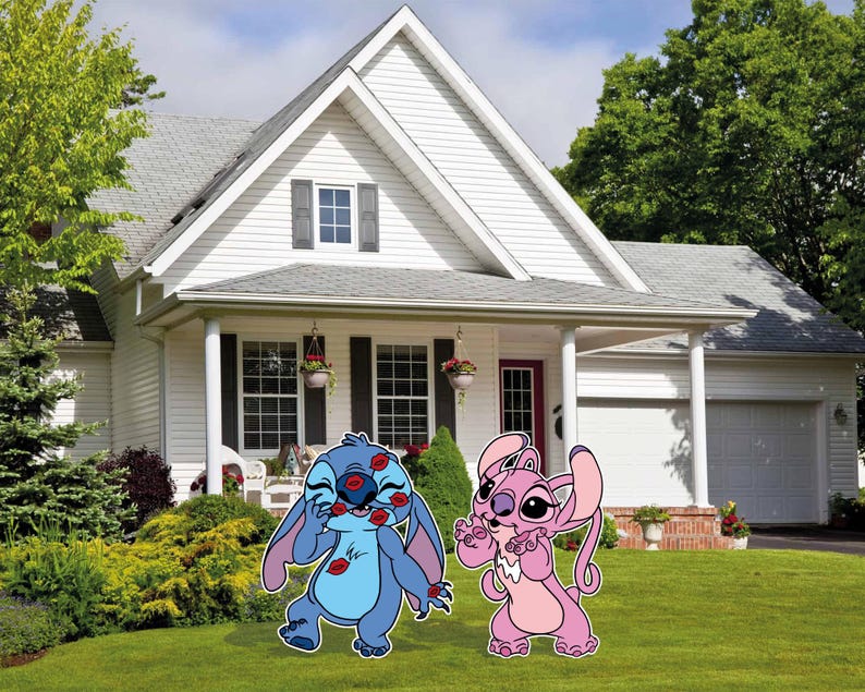 May include: Two cartoon characters, Stitch and Angel, stand in a green grassy yard in front of a white house. Stitch is blue with red lips and Angel is pink with a white collar.