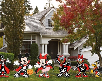 Puede incluir: Un conjunto de seis decoraciones de jardín de Halloween con Mickey Mouse, Minnie Mouse, Donald Duck, Daisy Duck, Goofy y Pluto vestidos de esqueletos y vampiros. Los personajes llevan capas rojas y sostienen calabazas.