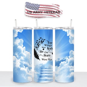 May include: A stainless steel tumbler with a blue sky and white clouds design. The tumbler has a black feather and birds flying upwards with the text "Your Wings Were Ready But Our Hearts Were Not".