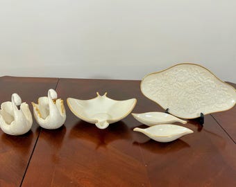 May include: Set of five white porcelain swan-shaped serving dishes with gold trim. The dishes include two small bowls, a larger bowl, and two small serving dishes.