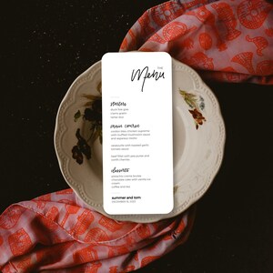 Może przedstawiać: Biała karta menu z czarnym tekstem, na której znajduje się menu na przyjęcie weselne. Menu zawiera przystawki, danie główne, desery oraz kawę i herbatę. Data ślubu to 16 grudnia 2025.