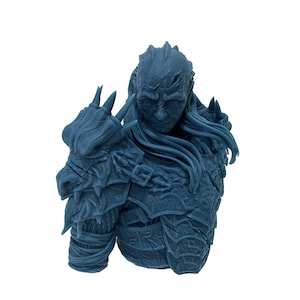 May include: A blue 3D printed bust of a warrior wearing armor with a dragon motif. The warrior has a long beard and a fierce expression.