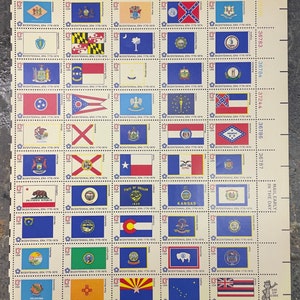 May include: A sheet of 13 US postage stamps featuring the flags of each state. The stamps are blue with white borders and the flags are in the center of each stamp. The stamps are arranged in a grid of 6 rows and 5 columns. The stamps are all from the Bicentennial Era 1776-1976.