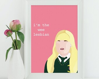 May include: A pink and white framed print with a cartoon illustration of a blonde girl wearing a green and gold uniform. The text on the print reads "i'm the wee lesbian".