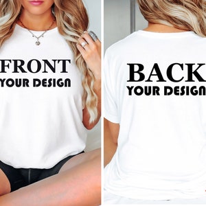 May include: White t-shirt with the text "FRONT YOUR DESIGN" on the front and "BACK YOUR DESIGN" on the back. The shirt is a basic crew neck style. The back of the shirt has a "BEST SELLING" sticker.