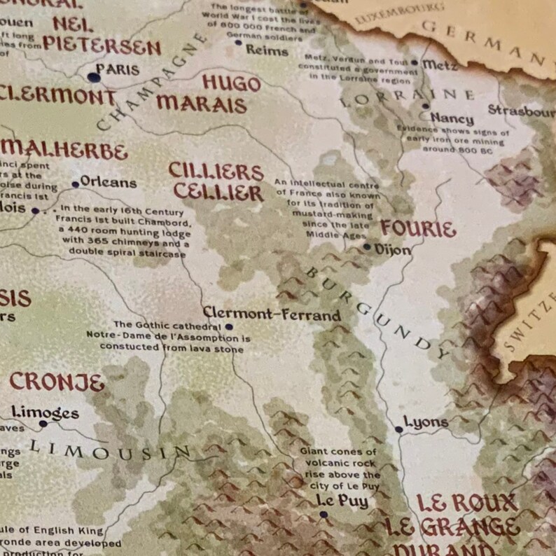 Puede incluir: Un mapa vintage de Francia con varias ciudades y regiones resaltadas. El mapa presenta un fondo marr&oacute;n con una superposici&oacute;n beige, mostrando las fronteras de cada regi&oacute;n. El mapa incluye texto que describe la historia y la importancia de cada regi&oacute;n.