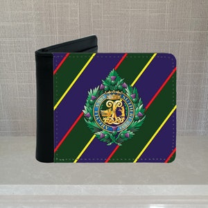 May include: A black leather wallet with a colorful design featuring a crest with the text "Argyll and Sutherland" surrounded by green leaves. The background is a green, yellow, red, and purple striped pattern.