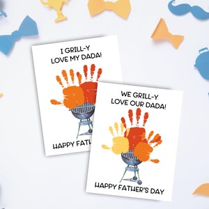 May include: Two white Father's Day cards with handprint art and the phrases "I Grill-y Love My Dada!" and "We Grill-y Love Our Dada!". The cards feature a watercolor grill illustration and the text "Happy Father's Day". Decorative cutouts surround the cards.