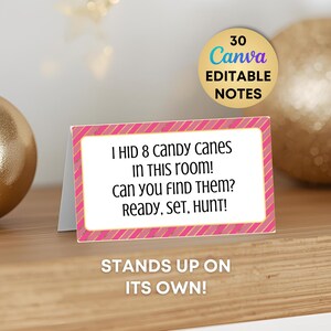 May include: A rectangular folded card with a pink and gold diagonal striped border. The white center features black text reading: I HID 8 CANDY CANES IN THIS ROOM! CAN YOU FIND THEM? READY, SET, HUNT! A gold circular badge above reads 30 CANVA EDITABLE NOTES.