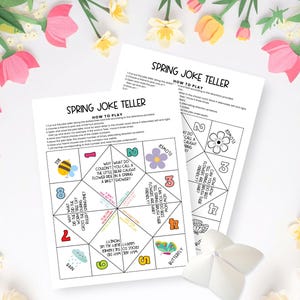 May include: Two white paper sheets titled Spring Joke Teller featuring instructions and a foldable game template with numbered sections, colorful illustrations of a bee, flower, butterfly, and rain cloud, and various spring-themed jokes in black text.