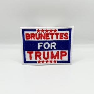 May include: A white, blue, and red embroidered patch with the text "Brunettes for Trump" and five stars above and below the text.