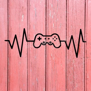 Puede incluir: Ilustración en blanco y negro de un mando de videojuego dentro de un latido del corazón estilizado. La imagen está sobre un fondo de madera rosa.