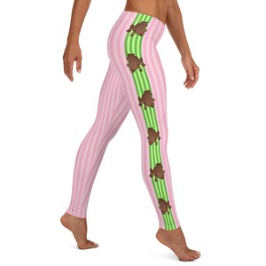 May include: Pink and green striped leggings with a repeating pattern of brown frogs on the side.