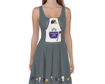 May include: A gray skater dress with a white apron design featuring a pot of steaming food, a spoon, and the text "Anyone Can Cook". The bottom of the dress has a repeating pattern of purple berries, yellow cheese wedges, and white chef hats.