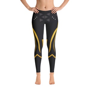May include: Black leggings with a geometric pattern in gold. The leggings have a black mesh background with a gold design.