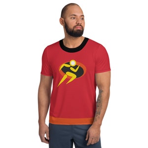 Pode incluir: Camiseta de treino vermelha, preta e amarela com uma figura estilizada de um corredor em um oval preto. A camiseta tem uma gola preta e uma faixa vermelha, laranja e amarela na parte inferior.