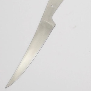 May include: A blank, silver knife blade with a rounded tip and three holes for mounting a handle.