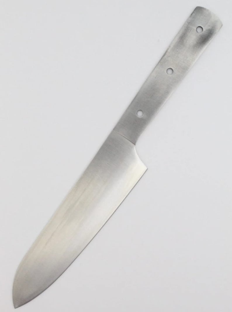 Op de afbeelding: Een blanco, roestvrijstalen mesblad met een handvat. Het blad is ongeveer 20 cm lang en heeft een afgeronde punt. Het handvat heeft vier geboorde gaten.