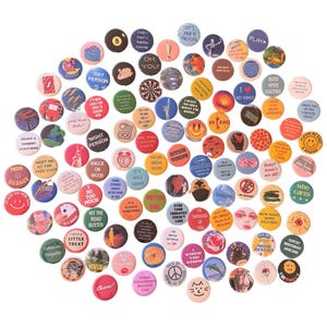 May include: A large collection of circular pin-back buttons featuring a wide variety of colorful graphic designs, illustrations, and text phrases. The buttons display diverse themes including smiley faces, food, animals, and humorous slogans.