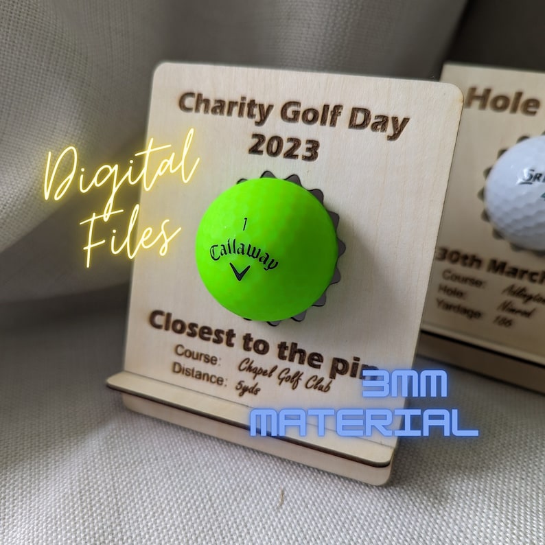 May include: A wooden plaque with the text "Charity Golf Day 2023" and "Closest to the pin" with a green golf ball attached to the plaque. The plaque is made of 3mm material.