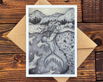 Può includere: Un'illustrazione in bianco e nero di una sirena con lunghi capelli fluenti, che nuota nell'oceano. È circondata da foche e fiori. Lo sfondo è una foresta oscura con montagne in lontananza.