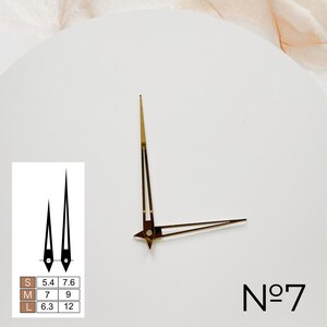 May include: Gold clock hands with a white background. The hands are labeled with sizes S, M, and L, with corresponding lengths in inches. The clock face also has the text "No. 7".