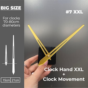 May include: A clock hand and movement set, labeled "#7 XXL." The gold-colored hands are shown against a black clock mechanism. The image includes text indicating the hands are for clocks with 70-80cm diameters. The clock hands measure 15cm and 21cm.
