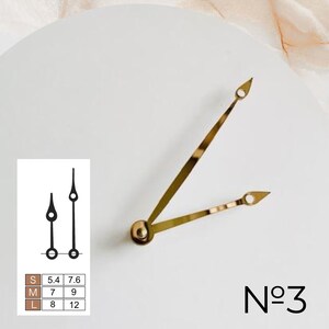 May include: Gold-colored clock hands with a rounded base and pointed tips, along with black clock hands. The image includes a size chart and the number "No 3". The clock hands are on a white background.