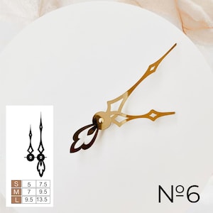 May include: Gold clock hands with a decorative design. The hands are on a white background with a size chart and the number "N&deg;6" in the bottom right corner.