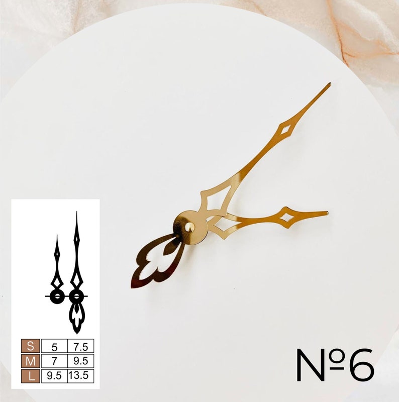 May include: Gold clock hands with a decorative design. The hands are on a white background with a size chart and the number "N&deg;6" in the bottom right corner.