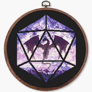 May include: Cross-stitch art in a wooden hoop. The design features a purple dragon inside a geometric shape, with a black background. The dragon is detailed with shades of purple and white.