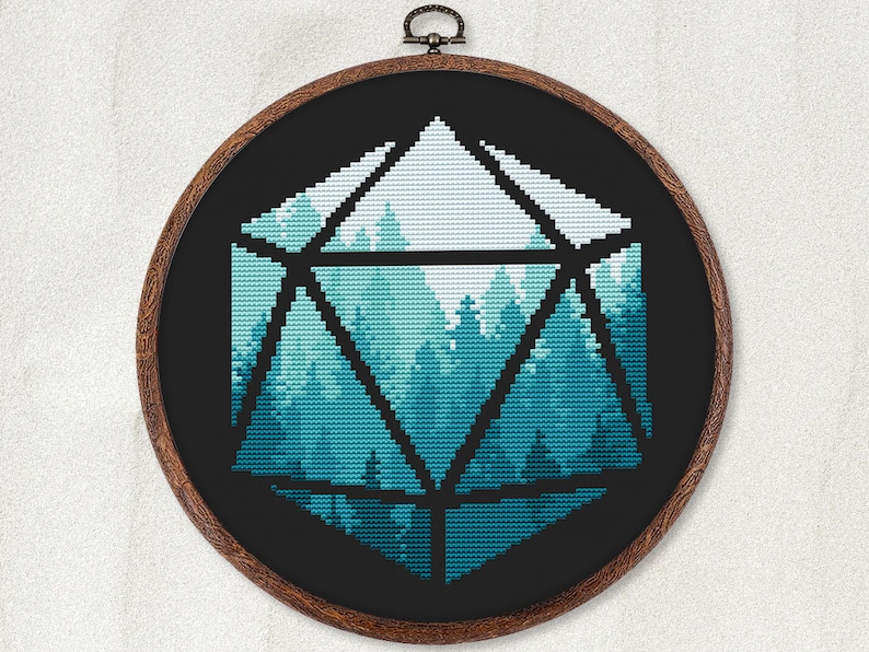 May include: A cross-stitch embroidery hoop with a black background and a blue and white geometric design of a forest scene inside a large, black, outlined, 3D dice shape.
