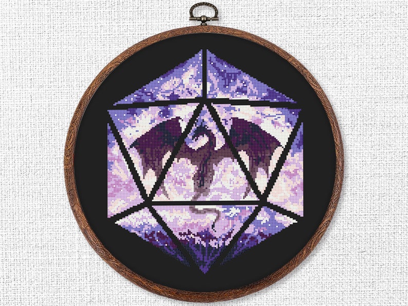 May include: A cross-stitch design featuring a purple dragon within a geometric shape, set against a black background. The artwork is framed in a round wooden hoop, showcasing a fantasy theme.