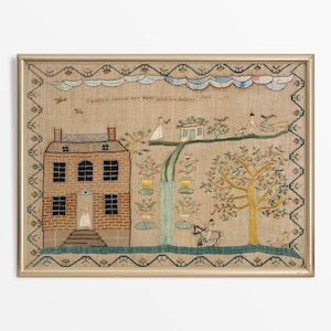 May include: Framed antique textile art with an embroidered scene. A brick house, figures, trees, and a waterfall are depicted. The artwork includes text at the top and is framed in a gold-coloured frame.