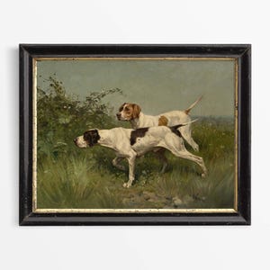 May include: An oil painting in a black frame depicts two hunting dogs in a field. The dogs are white with brown and black markings. The background features green foliage and a soft, muted sky.