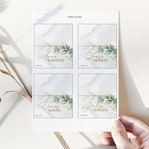 May include: Four place cards with a watercolor background and gold lettering. The names on the cards are Anna Radmond, Laura Hudson, Tomas Martin, and Helen Marshal.
