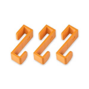 May include: Three orange plastic hooks, each with a simple S-shape design. The hooks are ideal for hanging lightweight items.