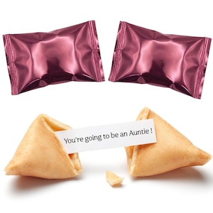 Pu&ograve; includere: Due biscotti della fortuna, uno rotto che rivela il messaggio "You're going to be an Auntie!". Due caramelle avvolte in carta stagnola rosa sono sullo sfondo. I biscotti sono marroni dorati. Il messaggio &egrave; su una striscia di carta bianca.