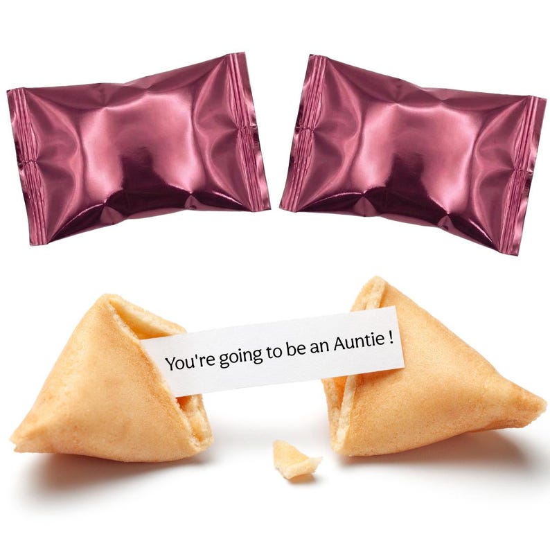 Pu&ograve; includere: Due biscotti della fortuna, uno rotto che rivela il messaggio "You're going to be an Auntie!". Due caramelle avvolte in carta stagnola rosa sono sullo sfondo. I biscotti sono marroni dorati. Il messaggio &egrave; su una striscia di carta bianca.