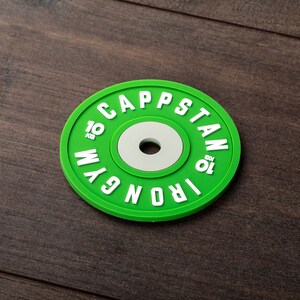 Pode incluir: Placa de peso verde com letras brancas que dizem "Iron Gym Capstan 10 kg".
